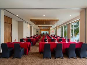 a banquet hall with red tables and black chairs at Swiss-Belhotel Papua in Jayapura +58 photos