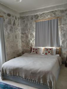 a bedroom with a bed with a stone wall at Route Cappadocia in Avanos
