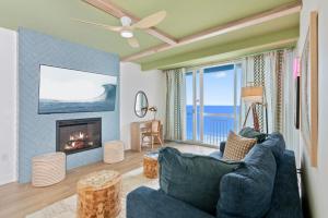 a living room with a blue couch and a fireplace at Penthouse 1BR + Bunk Room Boardwalk View Zone in Myrtle Beach