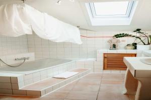 a white bathroom with a tub and a sink at Fischerstüberl Attel in Wasserburg am Inn +26 photos