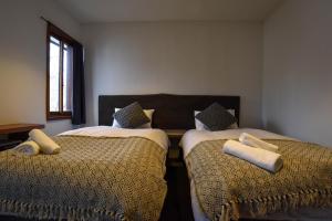a bedroom with two beds with pillows on them at The Joint in Hakuba