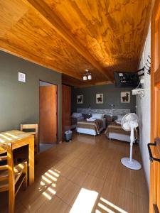 a living room with two beds and a wooden ceiling at Hostal Pablito in San Pedro de Atacama +57 photos