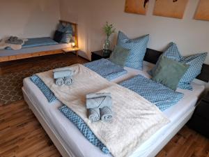 a bedroom with two beds with blue blankets and pillows at Ferienwohnung See und Sonne in Obing