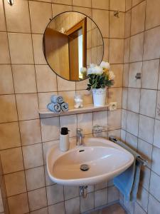 a bathroom with a sink and a mirror at Ferienwohnung See und Sonne in Obing +30 photos