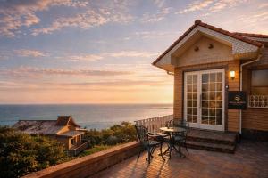 a house with a patio with a table and chairs at Villa Amoria in Miyazaki