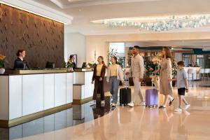 a group of people standing in a lobby with luggage at Malta Marriott Resort & Spa in St. Julianʼs +133 photos