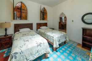 two beds in a bedroom with stained glass windows at Hotel Casa Grande in Taxco de Alarcón