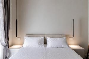 a bedroom with a bed with white sheets and two pillows at La Terrazza - Private Jacuzzi in Downtown Como in Como
