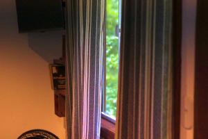 a window in a room with a curtain at Chalé Cabana Rústico refúgio e sossego há 1,5km do centro de Domingos Martins in Domingos Martins