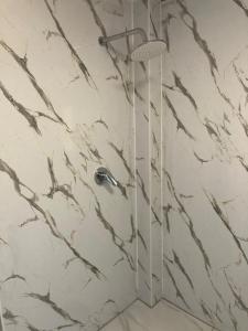 a shower in a bathroom with white marble walls at Daggoombah Holiday Home Magnetic Island in Arcadia +17 photos