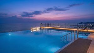a swimming pool at night next to the ocean at Urbanstay Naksan Beach in Yangyang