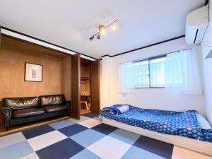 a bedroom with a couch and a checkered floor at NEXTRAVELER iNN in Osaka