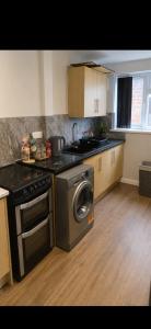a kitchen with a stove and a washing machine at Hunters lodge in Blackpool +1 photo