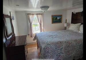 a bedroom with a bed and a window at Wolf Cove Retreat House in Amherst Cove