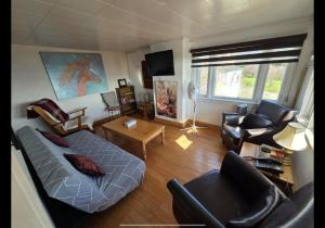 a living room with a bed and a couch and chairs at Wolf Cove Retreat House in Amherst Cove