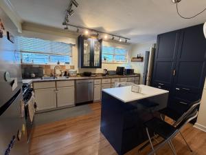 a kitchen with black cabinets and a white counter top at Bright & Spacious Full Family Home in Vancouver