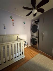 a baby room with a crib and a ceiling fan at Bright & Spacious Full Family Home in Vancouver