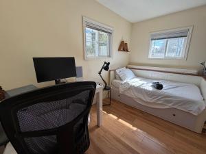 a bedroom with a bed and a desk with a computer at Bright & Spacious Full Family Home in Vancouver