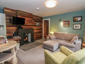 a living room with a couch and a fireplace at Puidrac Cottage in Lochearnhead