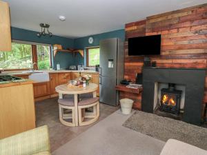 a kitchen with a fireplace and a table with a stove at Puidrac Cottage in Lochearnhead