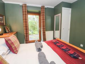 a bedroom with a bed with socks on it at Puidrac Cottage in Lochearnhead