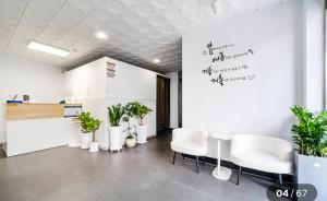 a waiting room with white chairs and plants at Hole in One Hotel in Chuncheon