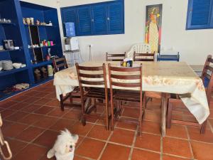 a white dog sitting next to a table and chairs at PÉ NA AREIA EM Pirangi do Norte in Parnamirim +3 photos