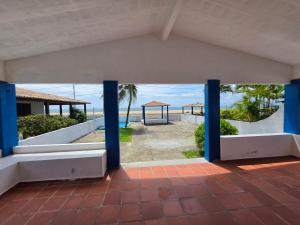 a view of the beach from a building with blue columns at PÉ NA AREIA EM Pirangi do Norte in Parnamirim