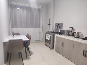 a kitchen with a table and chairs and a stove at Minidepartamento Independiente in San José de Chaltura