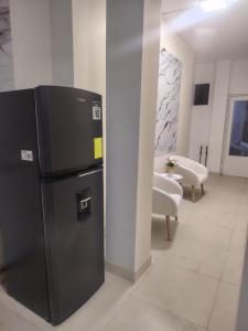 a black refrigerator in a room with chairs at Minidepartamento Independiente in San José de Chaltura