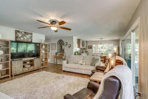 a living room with a couch and a tv at Pool & Dual Decks! Modern Trinity River Retreat in Lewiston