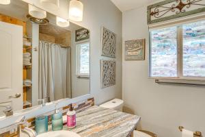 a bathroom with a sink and a toilet and a mirror at Pool & Dual Decks! Modern Trinity River Retreat in Lewiston +21 photos