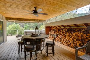 a patio with a table and a pile of wood at Pool & Dual Decks! Modern Trinity River Retreat in Lewiston
