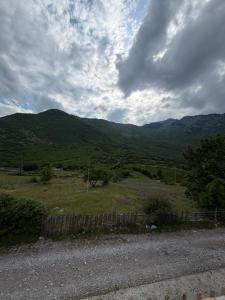 a field with a fence and mountains in the background at Villa Adi in Ducaj