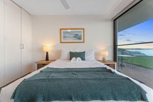 a bedroom with a large bed and a large window at Harbourside Unit 2 7 Soldiers Point Road in Soldiers Point
