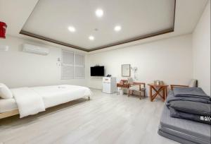 a bedroom with a bed and a desk and a tv at Hole in One Hotel in Chuncheon