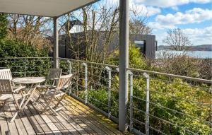 a porch with chairs and a table and a view of the water at 2 Bedroom Nice Apartment In Vejle Øst in Bredballe