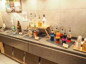 a counter with a bunch of bottles of alcohol at Super Hotel Shinbashi-Karasumoriguchi in Tokyo