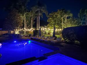 a swimming pool at night with chairs and lights at SolMaré - 5BR, Pool, Spa, Mini-Golf, Outdoor Kitchen, Fire Pit, Game Room in Bradenton +136 photos