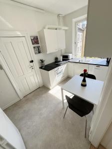 a white kitchen with a white table and a white counter top at Beautiful 2 Bedroom Apartment on Borgergade in Aalborg