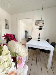 a white dining room with a white table and chairs at Beautiful 2 Bedroom Apartment on Borgergade in Aalborg +12 photos