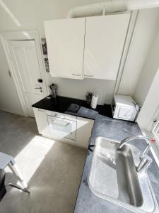 a kitchen with white cabinets and a sink at Beautiful 2 Bedroom Apartment on Borgergade in Aalborg