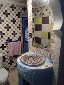 a bathroom with a toilet and a sink with a mirror at Dar Yassir in Chefchaouen