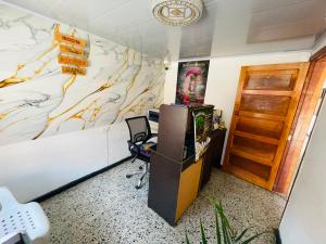 a room with a desk and a wall with a map at Hotel Colonial El Gran Fénix in Tunja