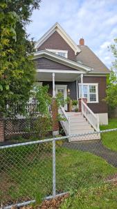 a house with a fence in front of it at Modern Two Bedroom Basement Apartment in Saint John