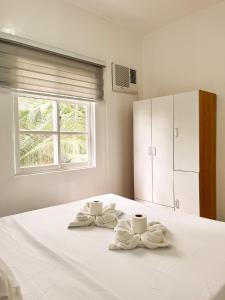 a bedroom with a bed with towels and a window at Zand Pointe Suites in General Luna +29 photos