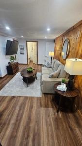 a living room with a couch and a tv at Modern Two Bedroom Basement Apartment in Saint John