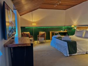 a bedroom with a bed and a table and chairs at Casa Capivari Boutique in Campos do Jordão