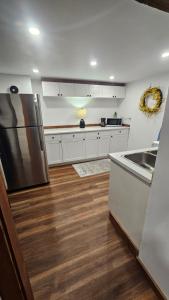 a kitchen with white cabinets and a stainless steel refrigerator at Modern Two Bedroom Basement Apartment in Saint John