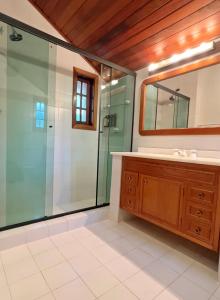 a bathroom with a shower and a sink and a mirror at Casa Capivari Boutique in Campos do Jordão +41 photos